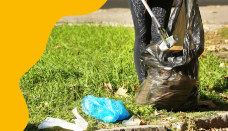 Henkilö kerää ulkona roskia säkkiin